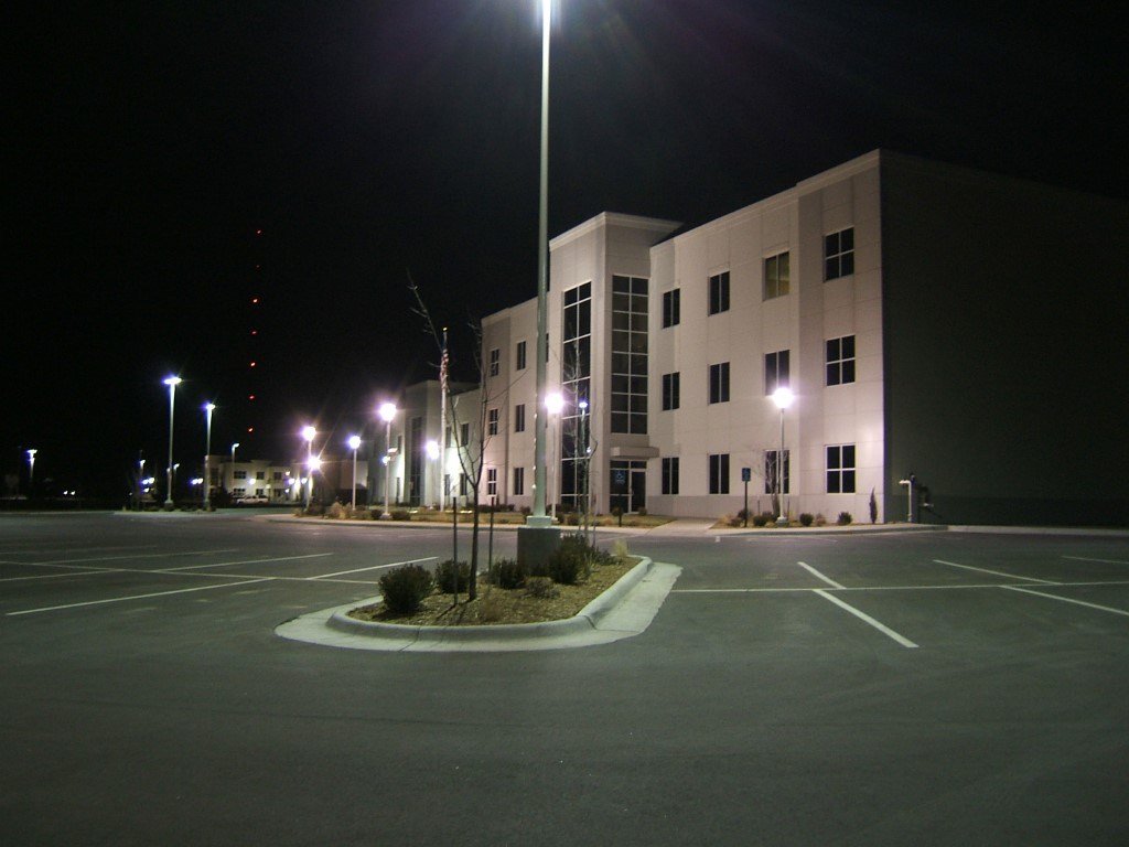 Outside image at night of a building and parking lot with exterior security lighting