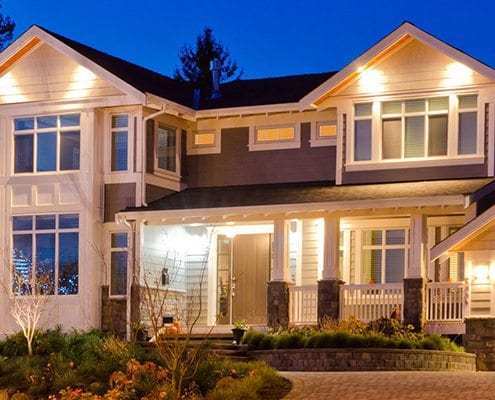 RESIDENTIAL-CROP photo of a home's exterior that has many lights on its porch and around windows for security and beauty