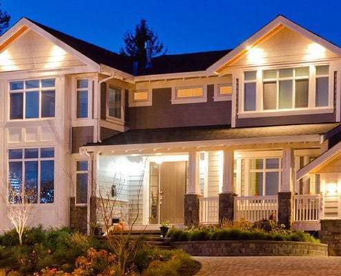 photo of a home's exterior that has many lights on its porch and around windows for security and beauty