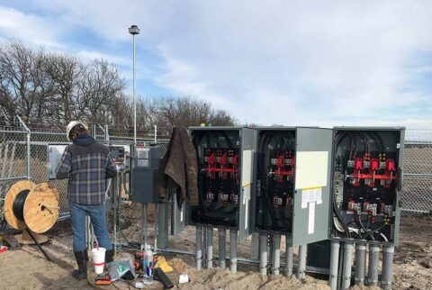 outside of a solar energy project with a Decker electrican working on a panel