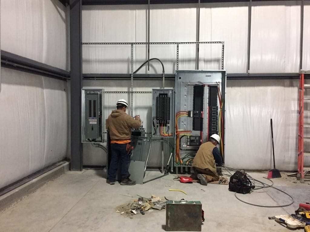 electricians-working Decker electricians working on wires inside panels