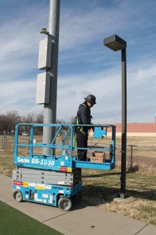 Decker Electric technician working on outdoor lighting at a high school