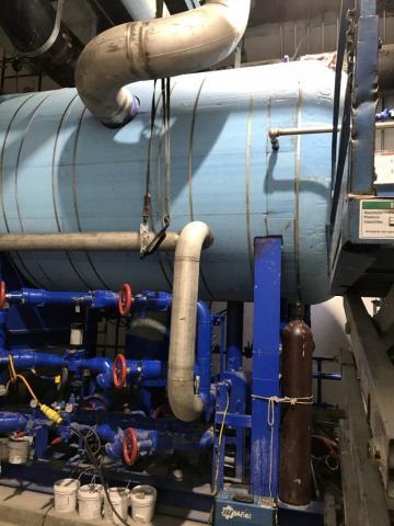 large container with a lot of pipes connected inside a plant, work by Decker Electric